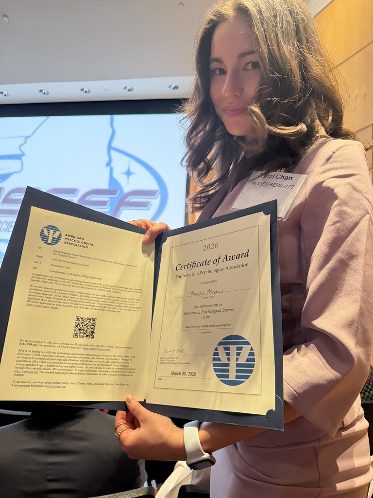 student smiling holidng award 