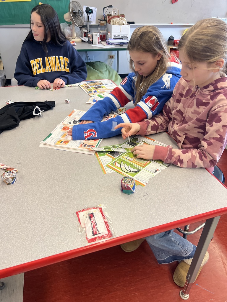 students sitting at desk with paper and tape 