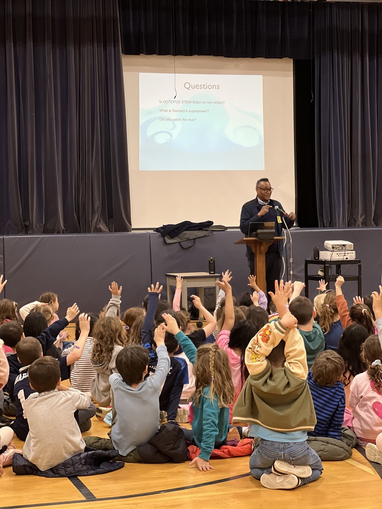 students sitting raising hands