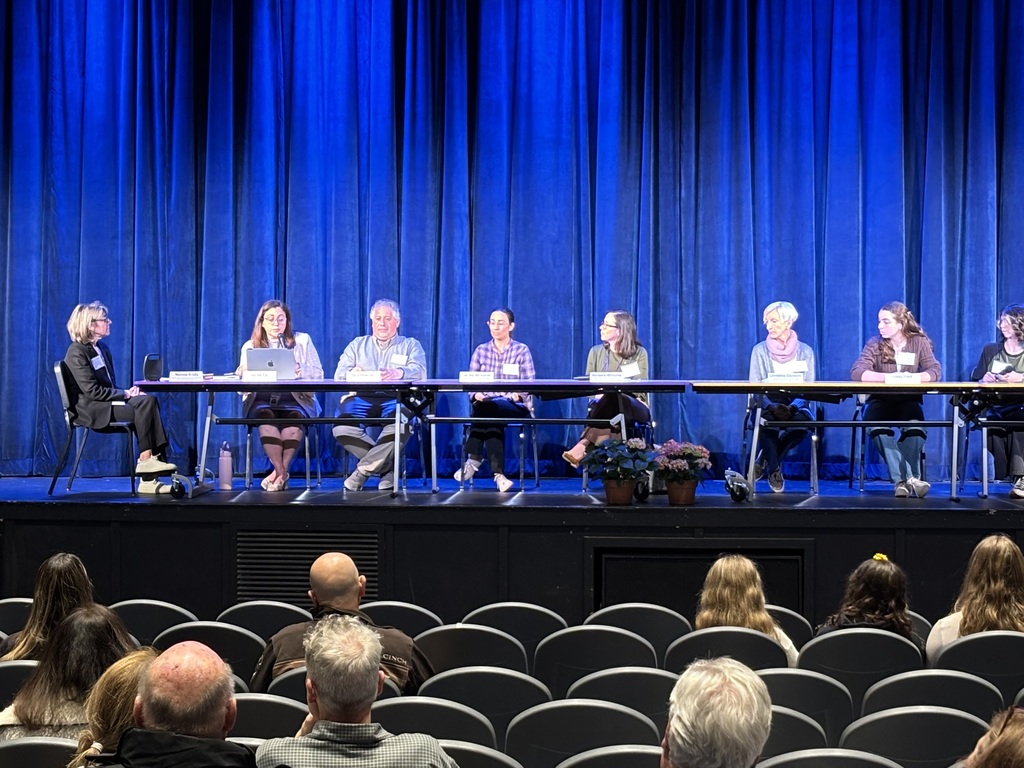people sitting at a table on stage