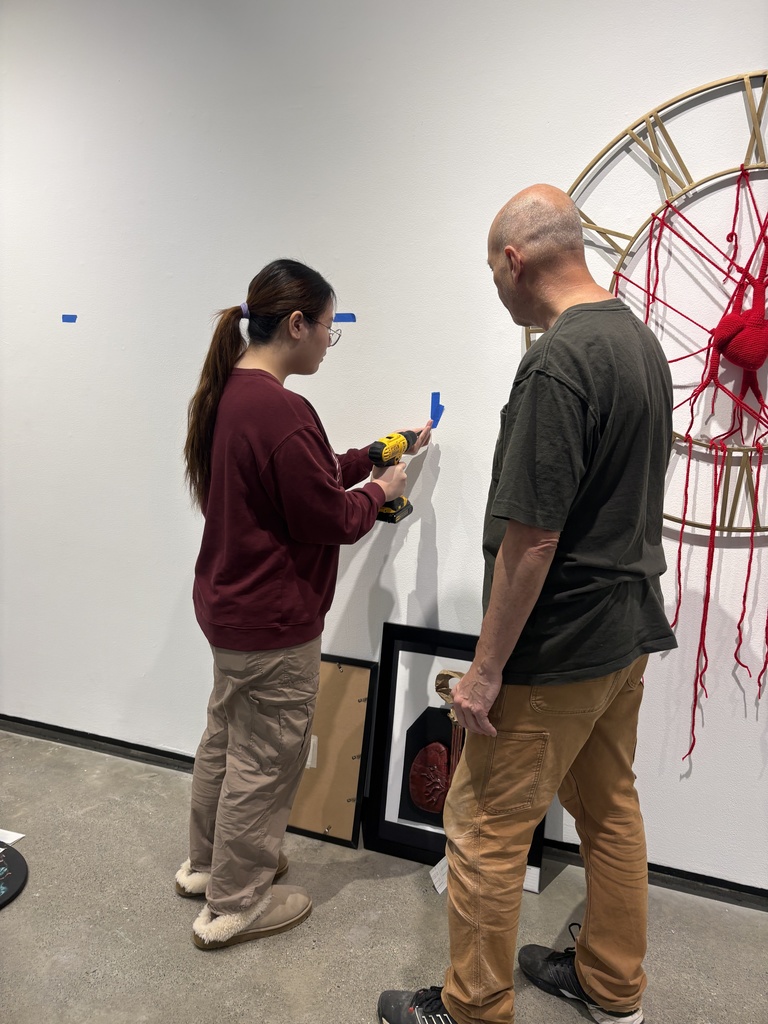 student installing artwork