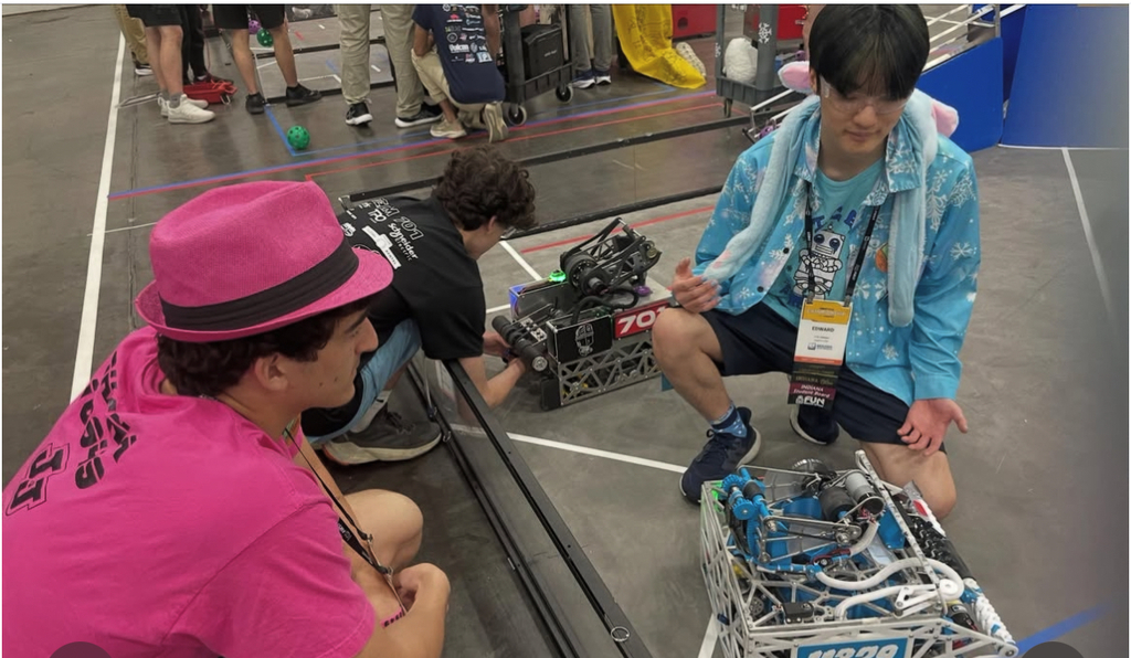 students standing and sitting with robot