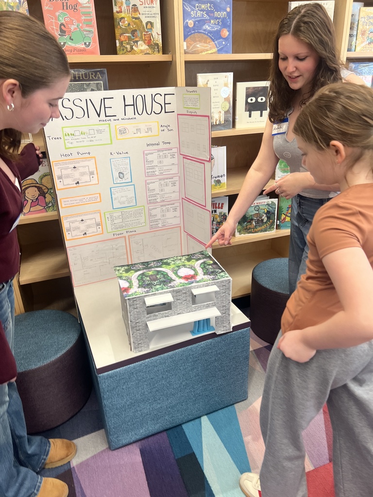 students look at model house 