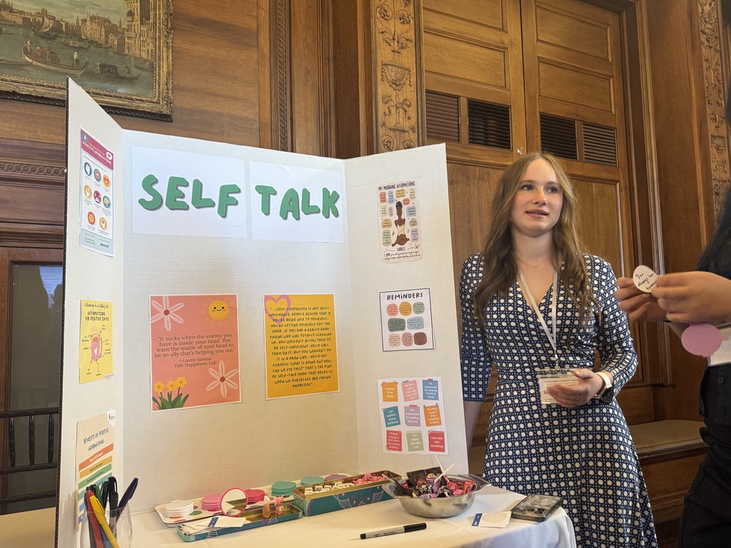 student standing with poster