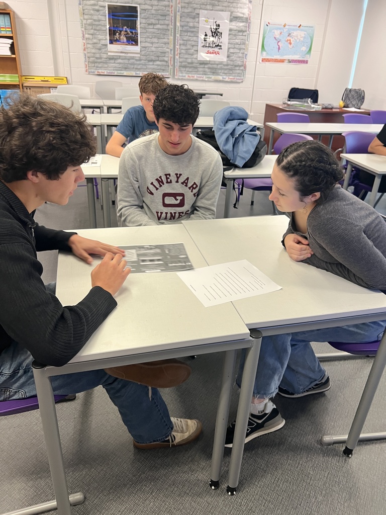 students sitting at desk talking 