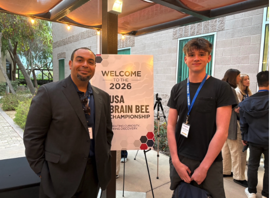 student and adult standing by poster