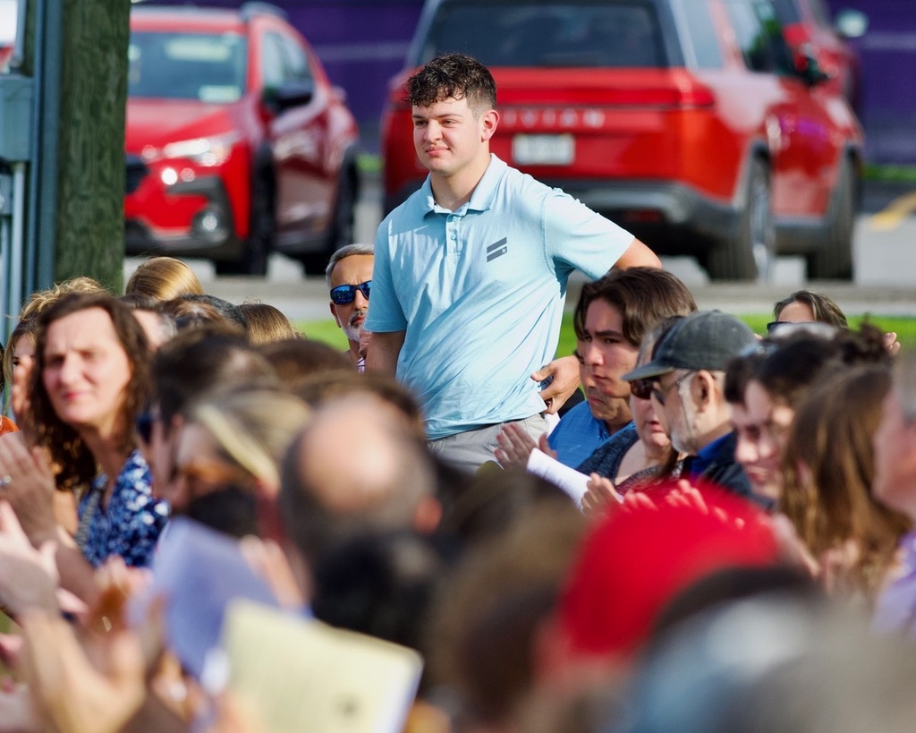 student standing adults sitting