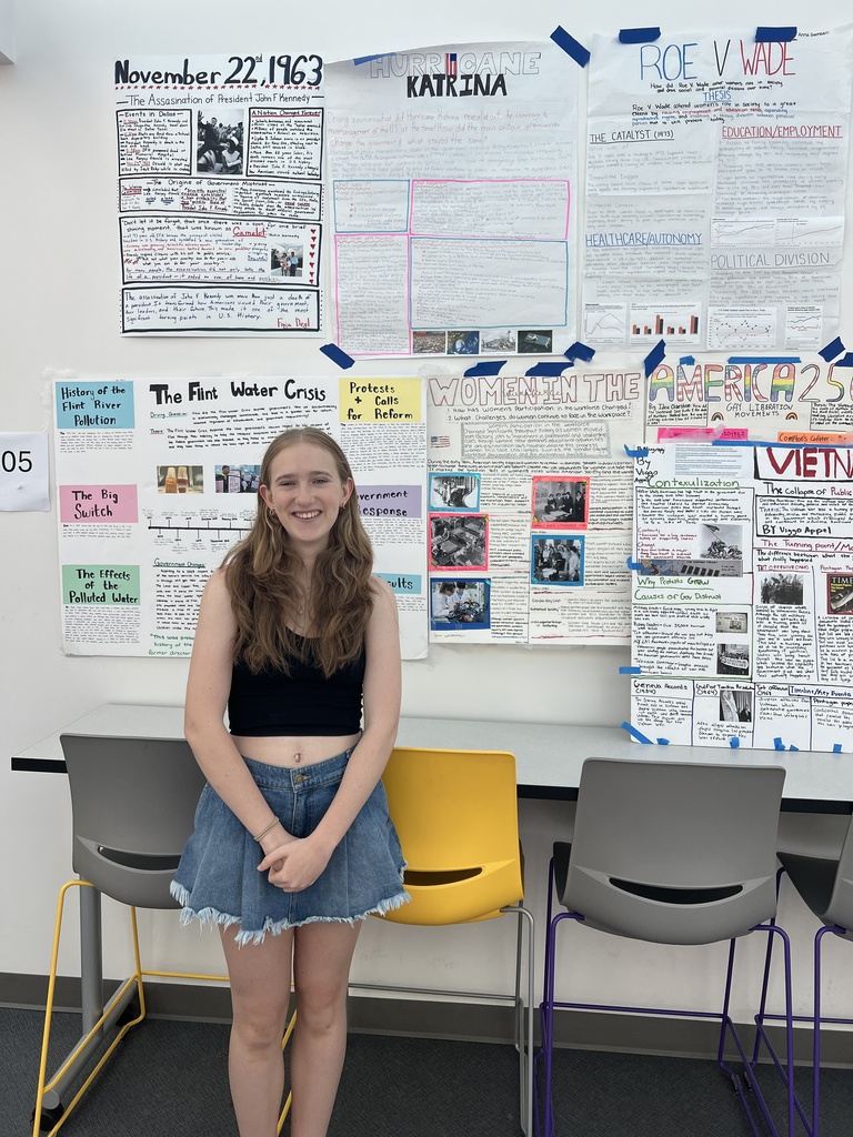 student standing in front of posters