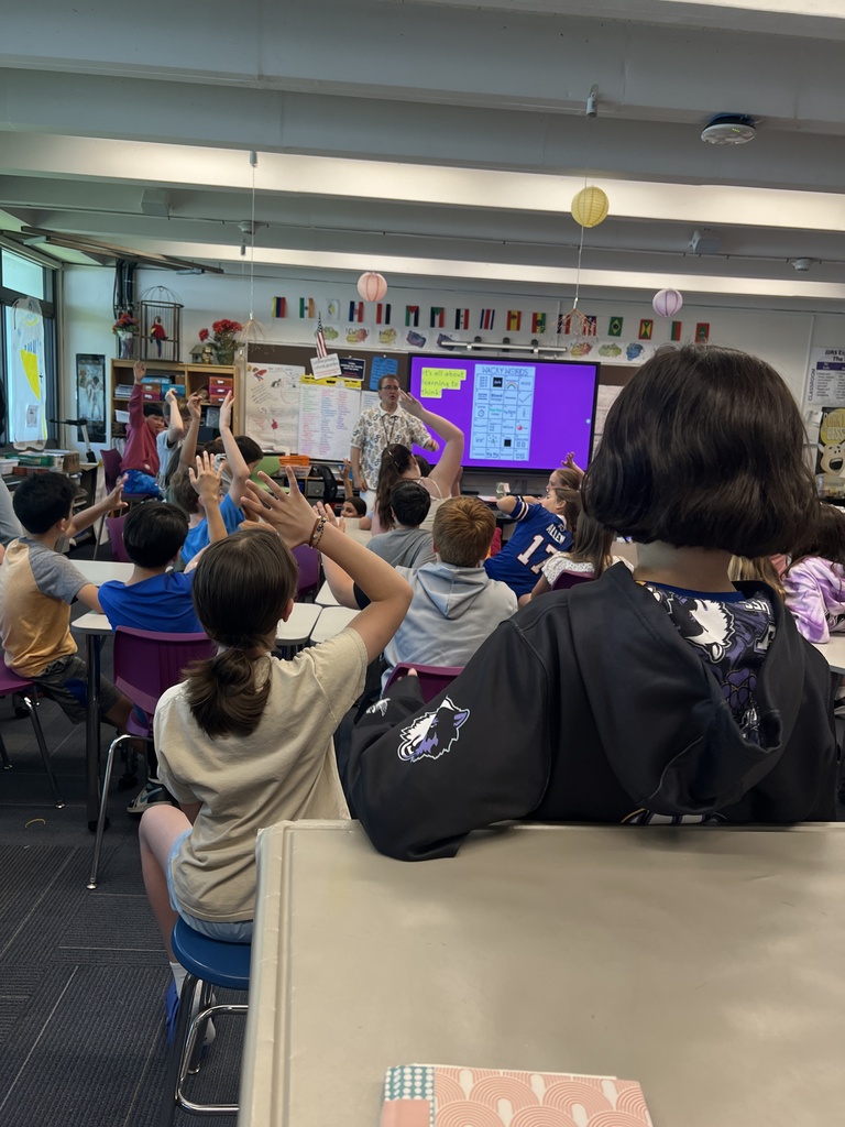 students sitting raising hands