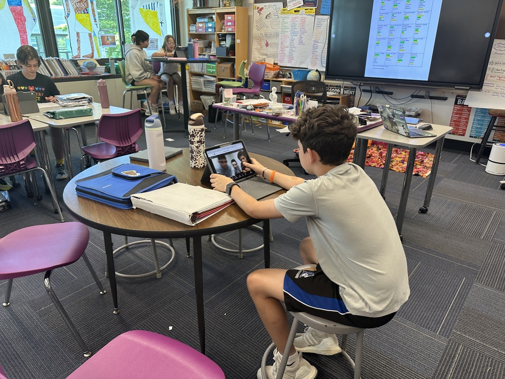 student sitting at desk on tablet