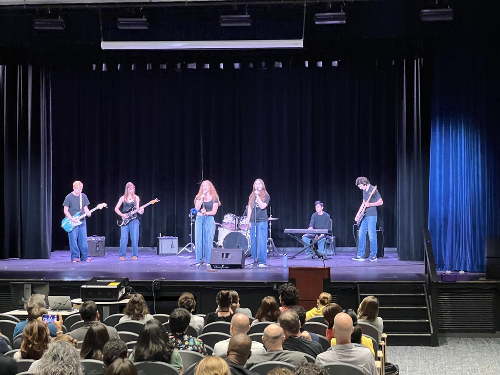 students on stage in a band playing instruments