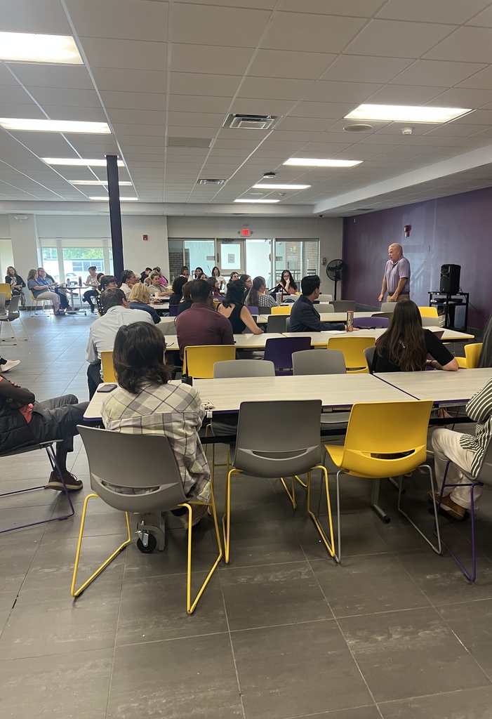 adult standing teachers sitting in cafeteria 