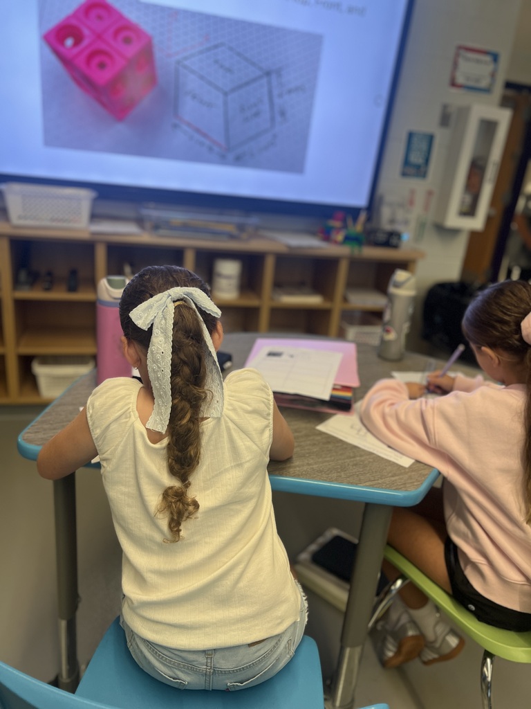 students sitting at desk drawing