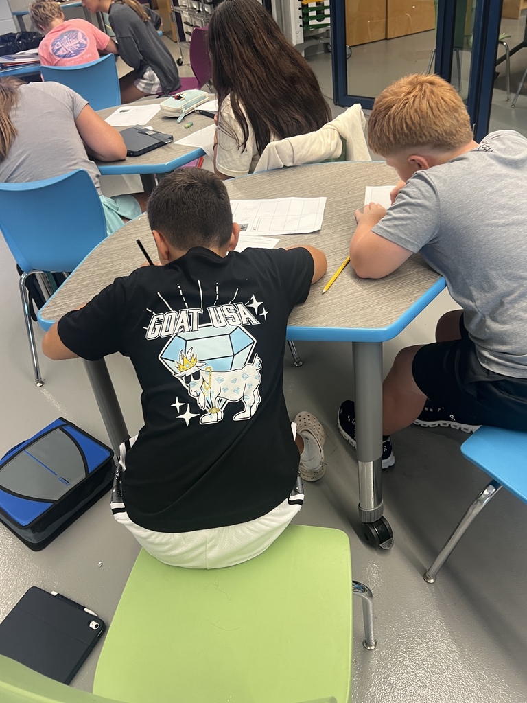 students sitting at desk drawing 