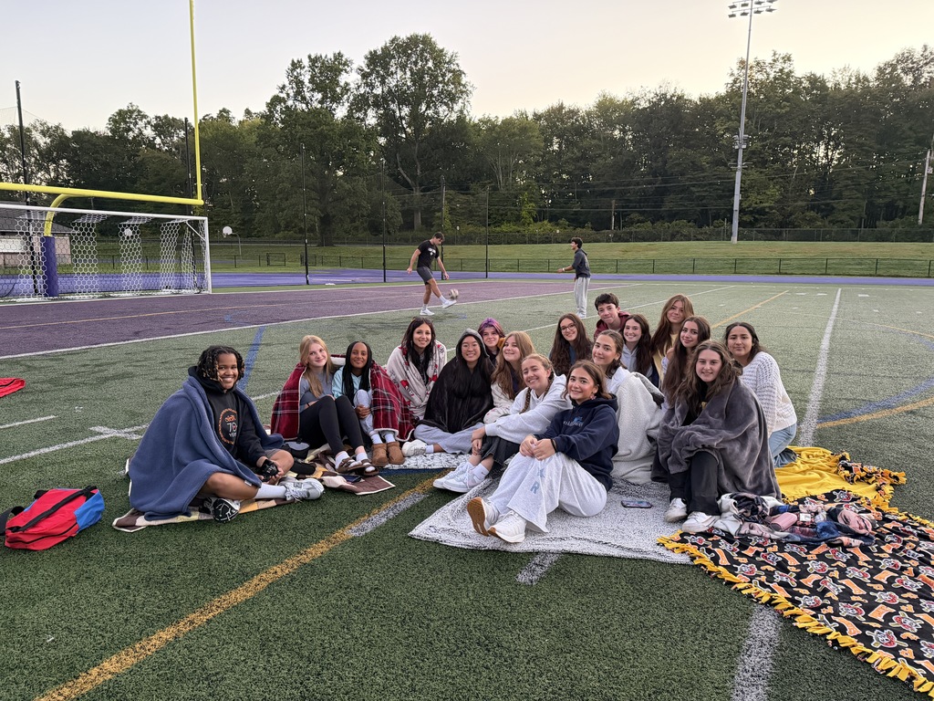 students sitting on field outside