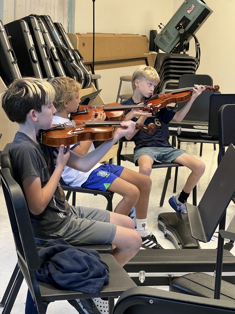 students sitting playing instruments