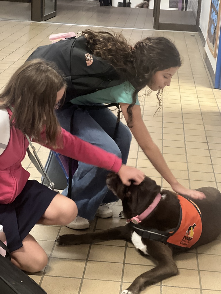 students in hallway with dog