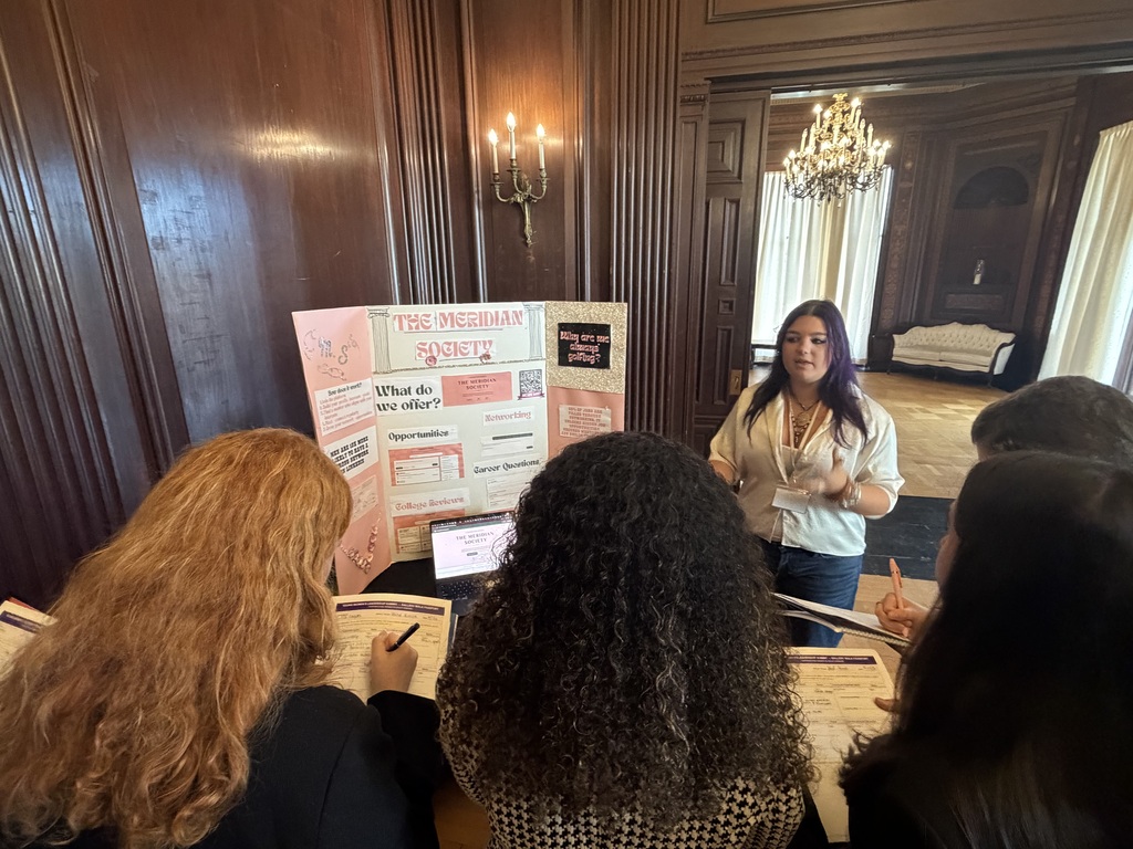 students standing by poster speaking