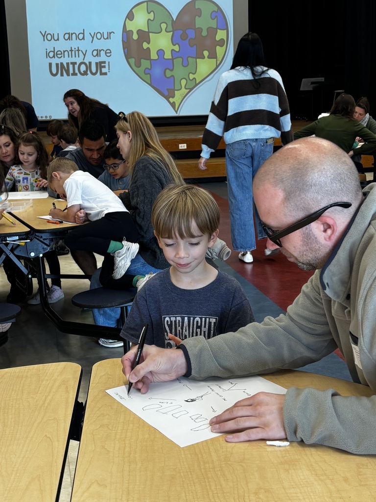 student and adult sitting at desk 