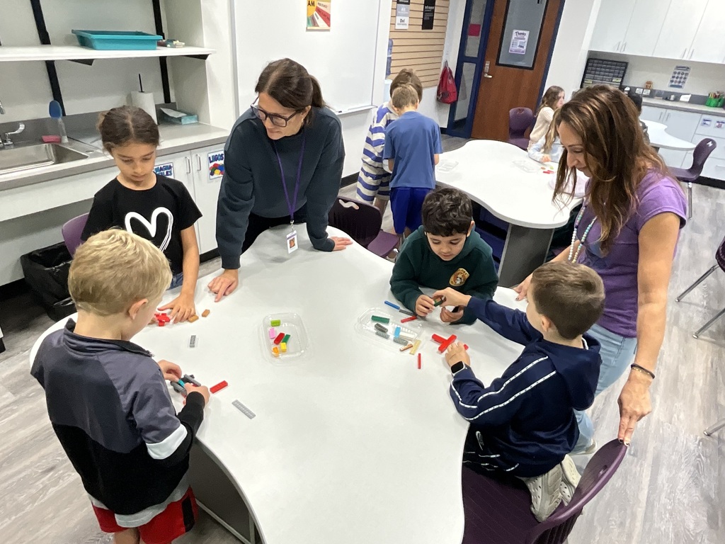 students sitting teachers standing at table