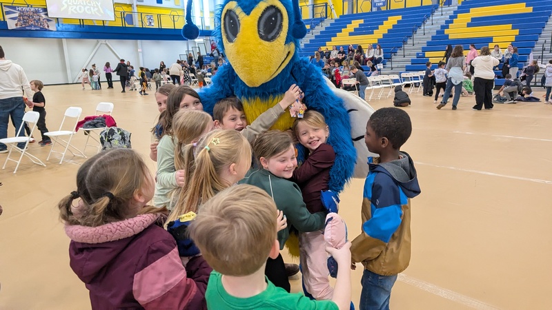 students hugging mascot