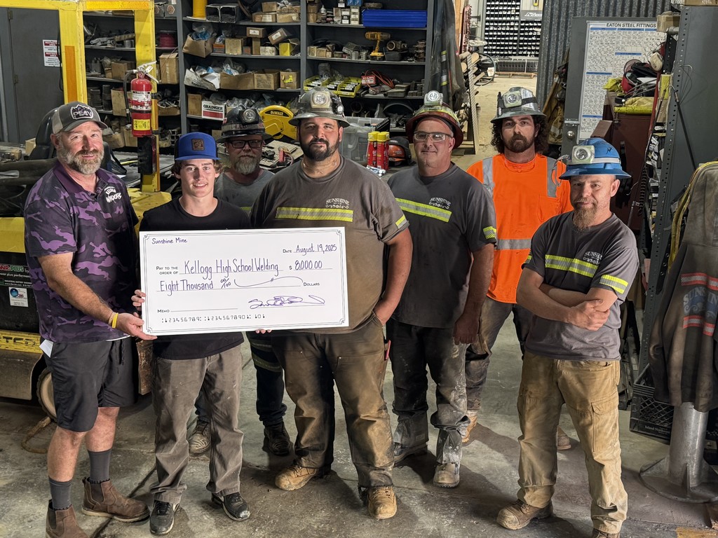 6 men and a student pose with a donation check