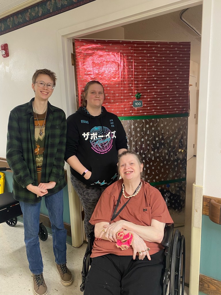 students and a resident posing with a decorated door