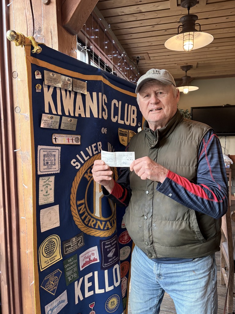 man posing with a donation check