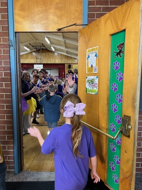 Students walking in gym for homecoming assembly