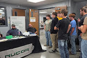 students talking to NUCOR