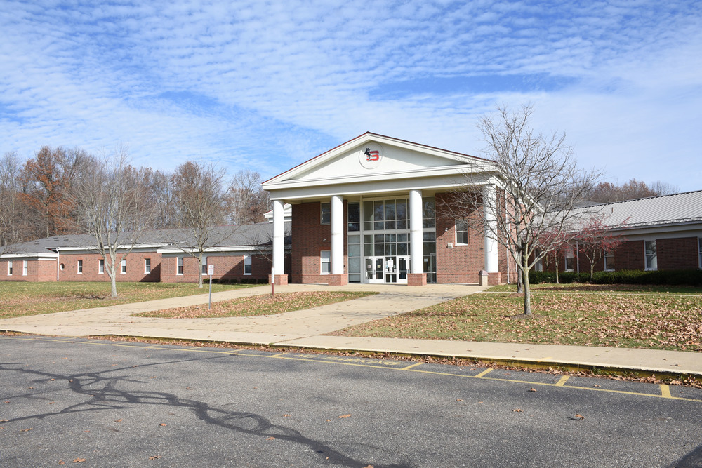 Outside of Stanton Middle School, brick building with white trim. Blue sky with wispy white clouds
