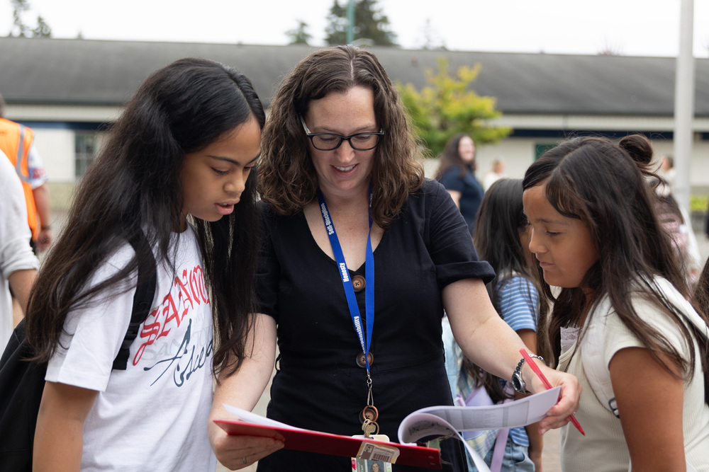 A Kent School District teacher speaks to two KSD students.