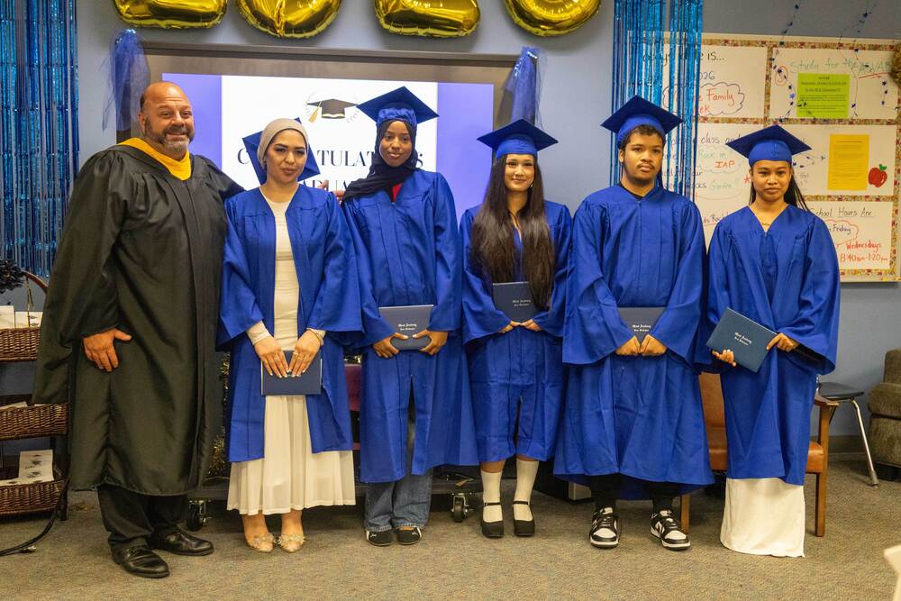 Principal Michael Williams poses with five students who received their diplomas during the iGrad summer graduation ceremony.