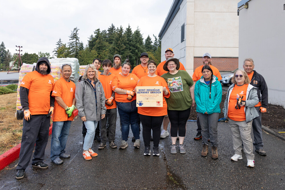 Home Depot volunteers pose during the dedication of a new sensory garden at Kent-Meridian High School.