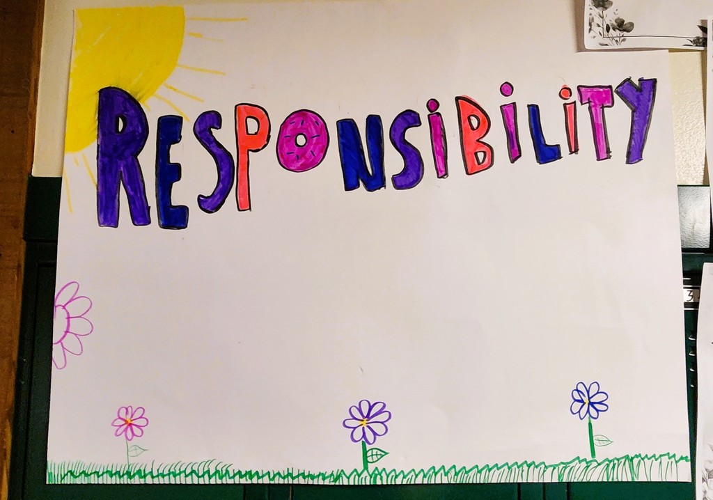 A hand made poster with the word "Responsibility" on it with a drawing of the sun and some flowers