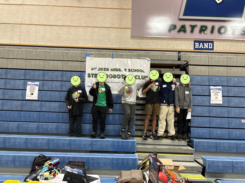 Meekers Robotics club poses for a picture together in front of a Meeker Middle School sign.  Faces have been covered with a smiling emoji per KSD safety protocol. 