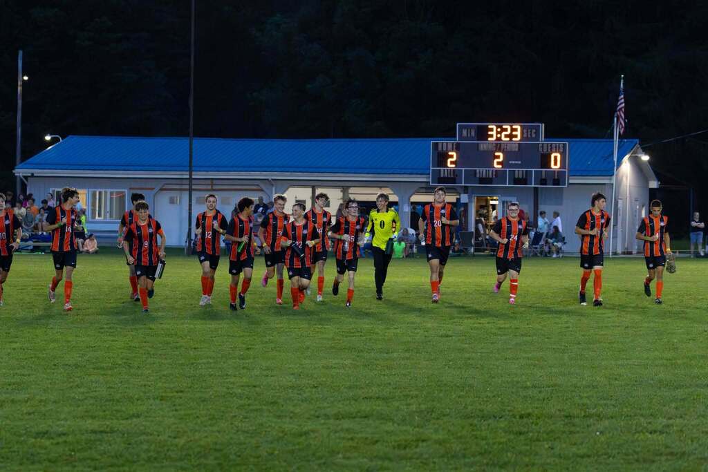 Boys soccer team runs back to sidelines after half time.