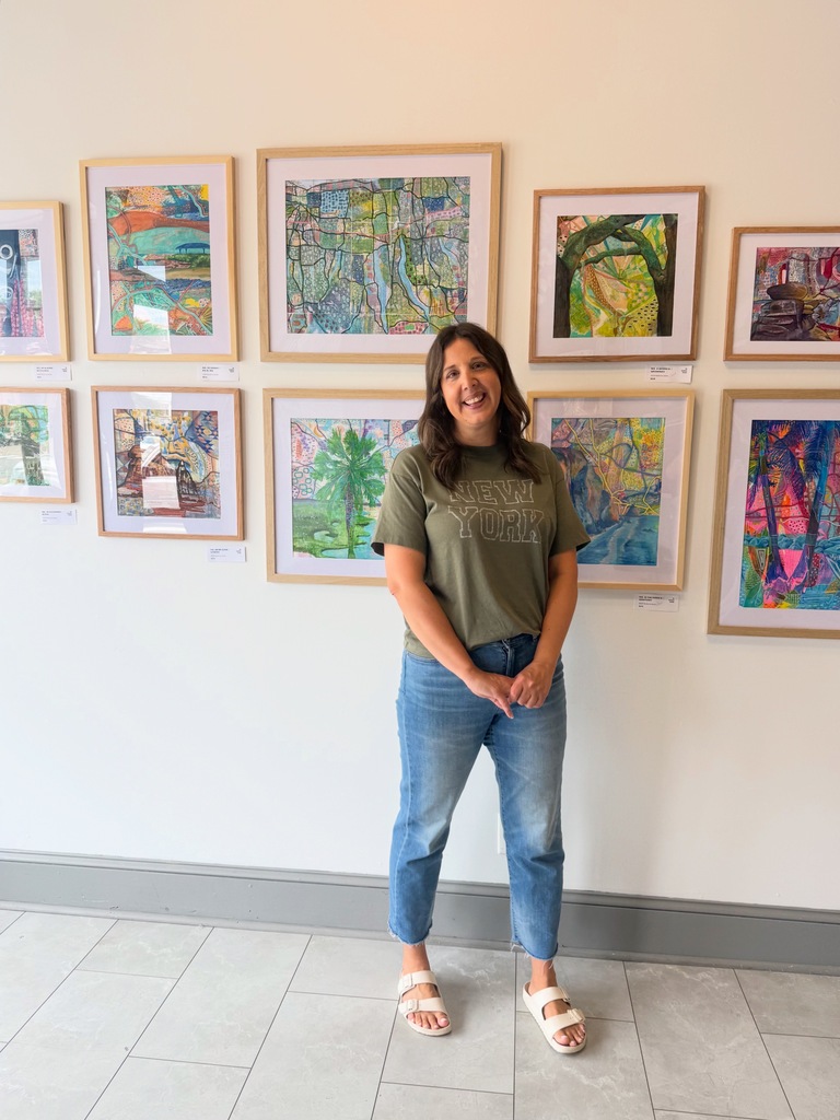 Mrs. Hartke stands in front of her artwork at The Gallery in the Valley