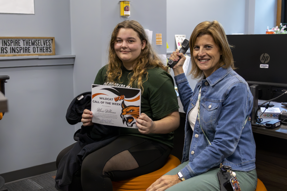 Students sit with Mrs. Kyle displaying their certificates