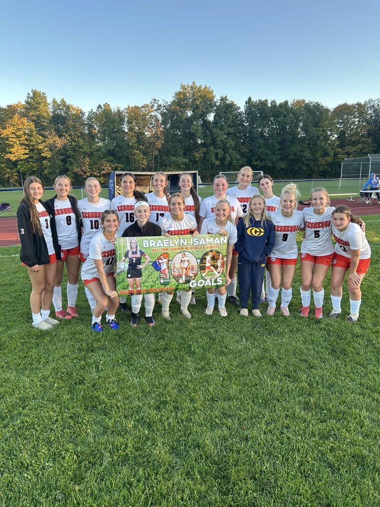 Braelyn Isaman stands with her 100th career goal banner
