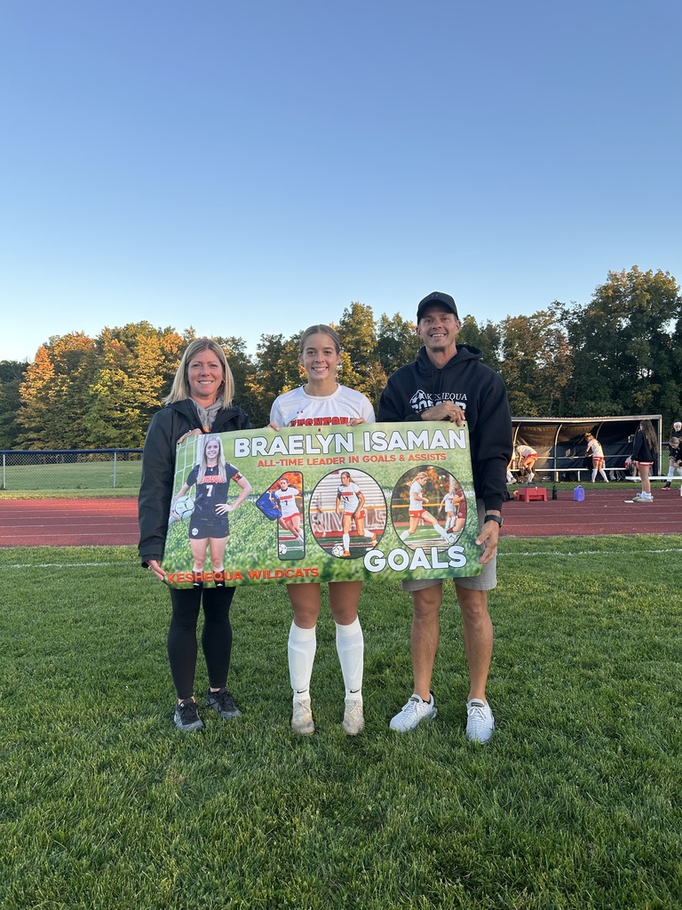 Braelyn Isaman stands with her 100th career goal banner