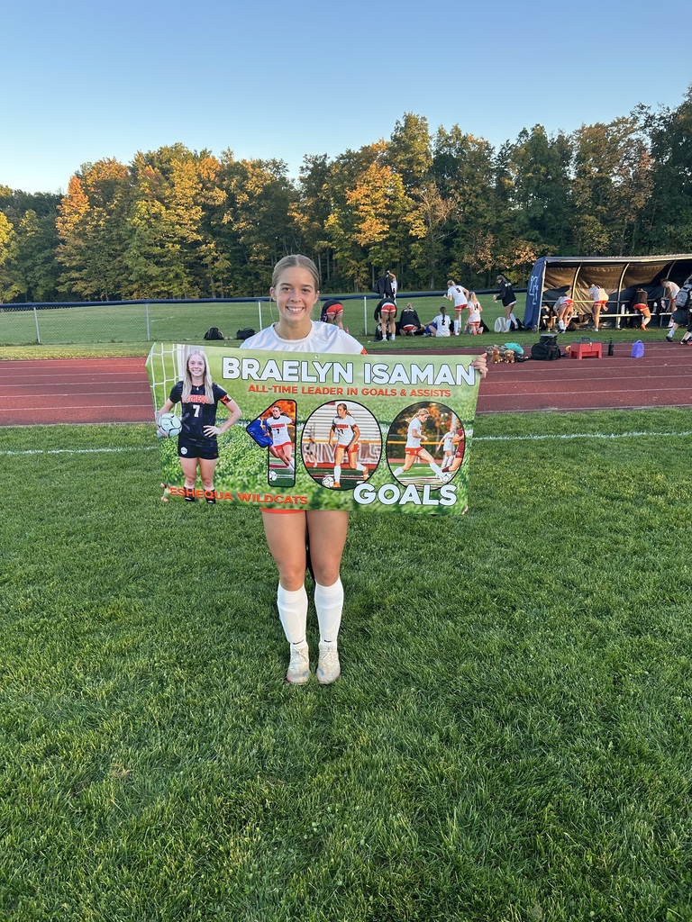 Braelyn Isaman stands with her 100th career goal banner