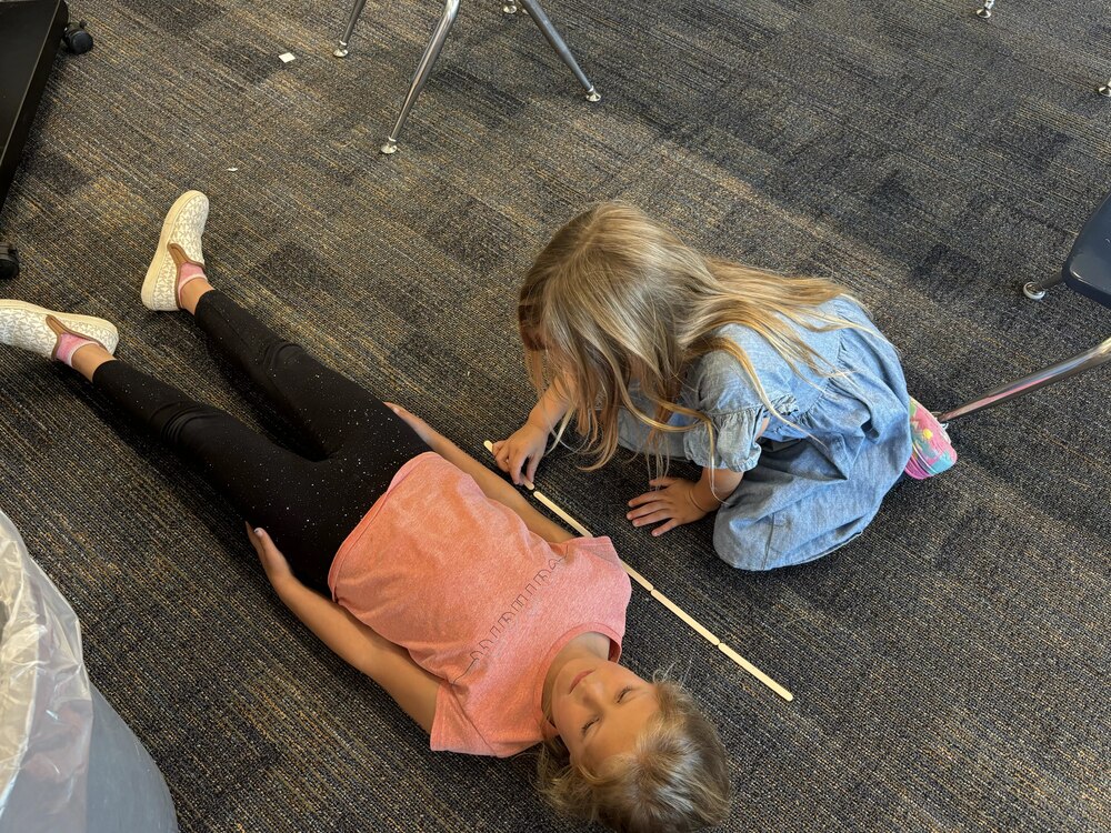 Student measuring with popcicle sticks