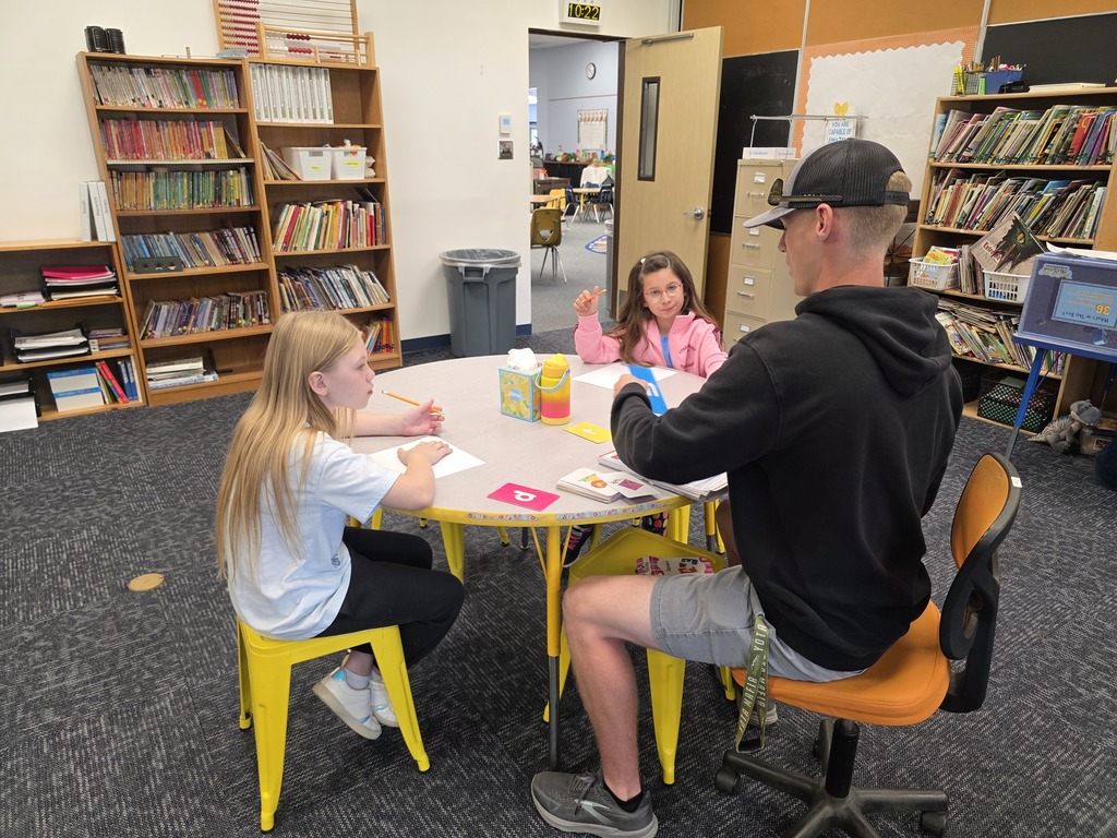Students doing hands-on phonics with paraeducator