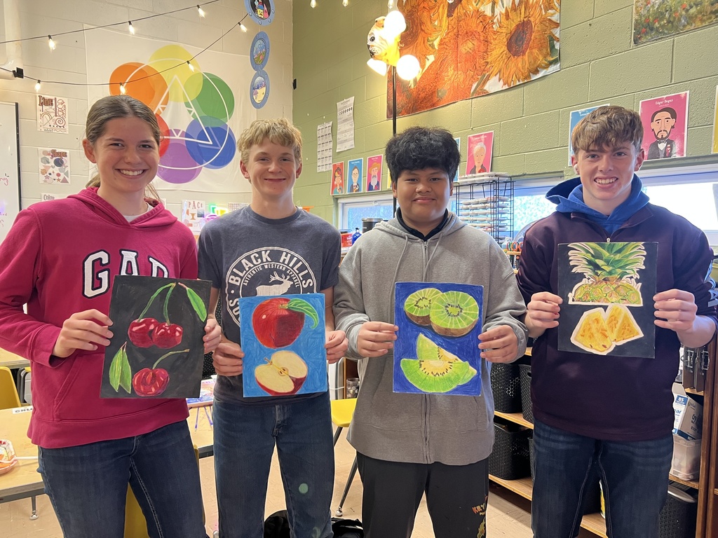 4 sophomores holding their pencil drawings of fruit
