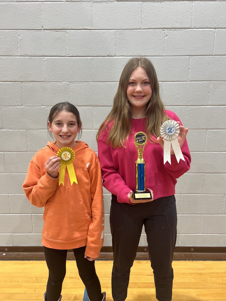 oral spelling bee winners with ribbons and trophy