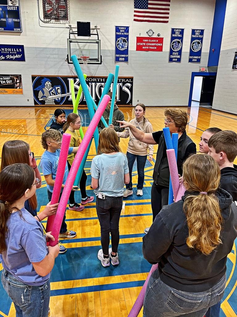 student with pool noodles