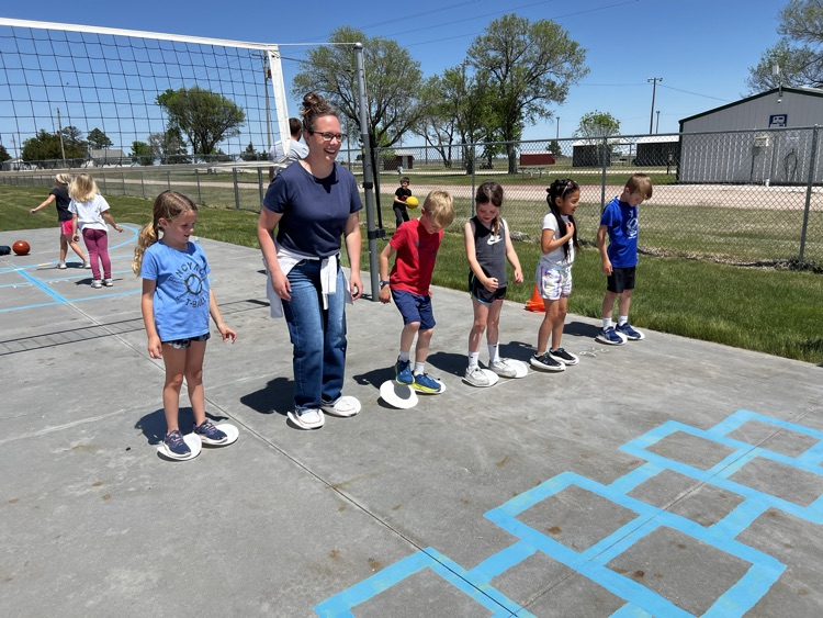 teacher doing a paper plate race with kids