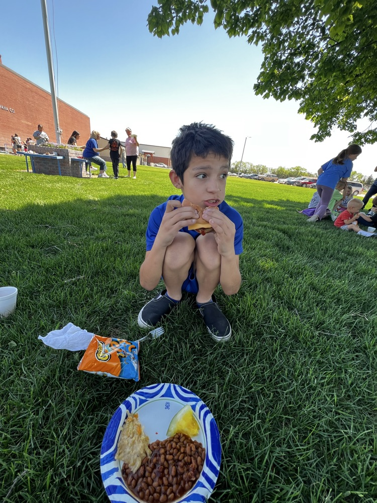 boy squatting on ground eating