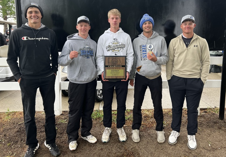 boys holding medals and district winner trophy